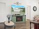 Living room with green TV stand, fireplace, and large TV showing house exterior at 341 Lake Suzanne Dr, Lake Wales, FL 33859