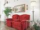 Red recliner in living room with hardwood floors and decorative accents at 341 Lake Suzanne Dr, Lake Wales, FL 33859