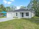 Newly built home showcasing a gray exterior, white garage, and grassy front yard at 815 S Seminole Ave, Fort Meade, FL 33841