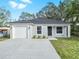 Newly constructed one-story home with a white garage door and landscaping at 815 S Seminole Ave, Fort Meade, FL 33841