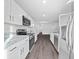 Long kitchen with white cabinets, stainless steel appliances, and granite countertops at 815 S Seminole Ave, Fort Meade, FL 33841