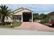 Tan house with carport and landscaped front yard at 337 Motorcoach S Dr, Polk City, FL 33868