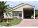 Tan house with carport and palm trees at 337 Motorcoach S Dr, Polk City, FL 33868
