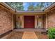 Front entry with double red doors and rocking chairs at 7510 Catherine Dr, Lakeland, FL 33810