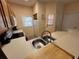 Kitchen with wood cabinets, white appliances, and double sink at 8425 Crystal Cove Loop, Kissimmee, FL 34747