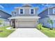 Two-story house with beige siding, a two-car garage, and landscaping at 1417 Leamington Ln, Winter Haven, FL 33884