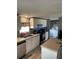 Open kitchen with white cabinets, stainless steel appliances, and an island at 50989 Highway 27 # 230, Davenport, FL 33897