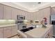 Modern kitchen with stainless steel appliances and light wood cabinets at 352 Meandering Way, Polk City, FL 33868