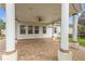 Spacious covered patio with brick flooring, ceiling fan, and white columns at 352 Meandering Way, Polk City, FL 33868