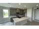 Modern kitchen with island, gray cabinets, and stainless steel appliances at 532 Adams View Ln, Auburndale, FL 33823