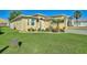Tan house with landscaping and paver driveway at 360 Motorcoach S Dr, Polk City, FL 33868