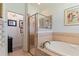 Spa-like bathroom with a large soaking tub, walk-in shower, and neutral tile at 360 Motorcoach S Dr, Polk City, FL 33868
