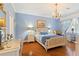 Bright bedroom with a light-colored wooden bed frame, hardwood floors and a blue color scheme at 360 Motorcoach S Dr, Polk City, FL 33868