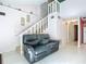 Living room features a black leather couch and stairs leading to an upper loft at 141 Fernery Rd # H1, Lakeland, FL 33809