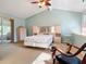 Main bedroom with a queen bed, access to a sunroom, and a rocking chair at 141 Fernery Rd # H1, Lakeland, FL 33809