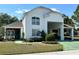 Two-story white house with a covered carport and well-manicured landscaping at 1214 Motorcoach Dr, Polk City, FL 33868