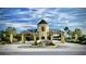 Gated entrance to a luxury community with a stone building and lush landscaping at 6265 Pinehurst Loop, Winter Haven, FL 33884