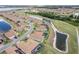 Aerial view of homes near a golf course and lake at 6265 Pinehurst Loop, Winter Haven, FL 33884