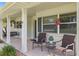 Charming front porch with white columns, wicker chairs, and a porch swing at 274 Paradise Island Dr, Haines City, FL 33844