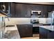 Modern kitchen with dark cabinets, granite countertops, and stainless steel appliances at 3671 E Gaskins Rd, Bartow, FL 33830