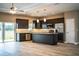 Modern kitchen with dark cabinets, granite countertops, stainless steel appliances, and an island at 3671 E Gaskins Rd, Bartow, FL 33830