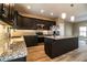 Modern kitchen featuring dark cabinets, granite countertops, stainless steel appliances, and an island at 3671 E Gaskins Rd, Bartow, FL 33830