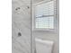 Updated bathroom with marble shower tile and a new toilet at 724 Hillside Ave, Lake Wales, FL 33853