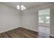 Simple dining room with wood flooring and view into sunroom at 318 Senate St, Auburndale, FL 33823