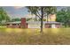 Back exterior view of brick home with sunroom and expansive lawn at 3479 Arrowwood Dr, Lakeland, FL 33811