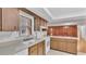 Kitchen features wood cabinets, white appliances, and a breakfast bar at 3479 Arrowwood Dr, Lakeland, FL 33811