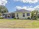Yellow house with covered patio and lush landscaping at 745 Square Lake E Dr, Bartow, FL 33830