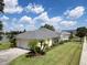 Yellow house with gray roof, two-car garage, and landscaped yard at 745 Square Lake E Dr, Bartow, FL 33830