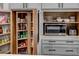 Organized pantry with a pull-out shelving system and microwave at 745 Square Lake E Dr, Bartow, FL 33830