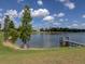Serene lakefront property with private dock, lush landscaping, and mature trees at 745 Square Lake E Dr, Bartow, FL 33830