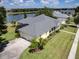 Yellow house with gray roof, two-car garage, and lake view at 745 Square Lake E Dr, Bartow, FL 33830
