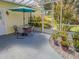 Covered patio with table and chairs, surrounded by lush landscaping at 745 Square Lake E Dr, Bartow, FL 33830