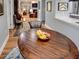 Round wooden dining table with fruit bowl, view into living room at 745 Square Lake E Dr, Bartow, FL 33830