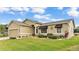 Tan house with a two-car garage, lush lawn, and landscaping at 5879 Swallow Dr, Lakeland, FL 33809