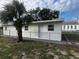 Newly painted home with chain link fence and palm tree at 143 D St, Lake Wales, FL 33853
