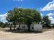 White house exterior with mature trees and a gravel driveway at 143 D St, Lake Wales, FL 33853