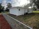 Rear view of a single story home with a chain link fence and red mulch beds at 143 D St, Lake Wales, FL 33853