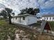 Front view of a freshly painted house with a chain link fence and manicured landscaping at 143 D St, Lake Wales, FL 33853