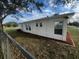 Newly renovated house exterior with a landscaped yard and chain link fence at 143 D St, Lake Wales, FL 33853