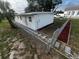 Side view of a newly painted house with chain link fence and landscaped yard at 143 D St, Lake Wales, FL 33853