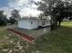 Side view of a single story home with a chain link fence and red mulch beds at 143 D St, Lake Wales, FL 33853