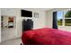 Comfortable bedroom with a red comforter, dresser and access to home gym at 5600 Siltstone St, Lakeland, FL 33811
