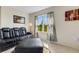 Living room features a black leather couch, ottoman, and large window at 5600 Siltstone St, Lakeland, FL 33811