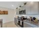 Modern kitchen with gray cabinets, granite countertops, and stainless steel appliances at 5600 Siltstone St, Lakeland, FL 33811