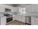 Modern kitchen featuring white cabinets, stainless steel appliances, and granite countertops at 401 Sw 1St Ave, Mulberry, FL 33860