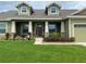 Two story house with a green exterior, large front yard, and a stone accented porch at 2875 Creeks Crossing Blvd, Lakeland, FL 33810